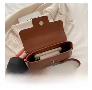 Détail de l'intérieur spacieux du sac bandoulière marron avec bandoulière en chaîne argentée
