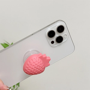 Close-up of pink 3D strawberry foldable phone grip with textured silicone surface