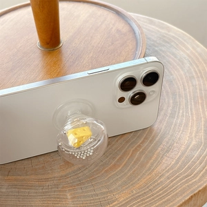 Creative clear sphere phone grip with 3D cheese model and silver beads on white phone