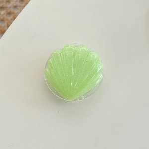 Macro detail of mint green shell phone grip with glitter resin texture and 3D effect