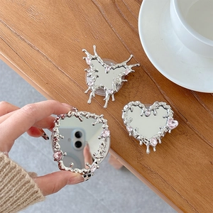 Detail of silver heart and butterfly phone grips with liquid metal design and pink gems