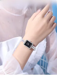 Detail of elegant rectangular watch with diamond-set bezel and double-row pearl strap