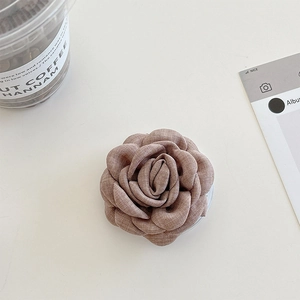 Vue détaillée du support téléphone fleur de camélia en tissu avec pétales rose poudré