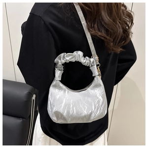 Detail of silver crescent bag with ruched handle and metallic crinkled texture