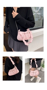 Detail of pink pleated PU shoulder bag with decorative pearl chain and metal strap