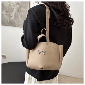 Detail der beige Schultertasche mit silberner Metall-Schleifenschnalle und Glattleder