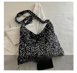 Vue détaillée de sequins noirs scintillants sur un grand sac à bandoulière pour femme
