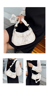 Close-up of white pleated hobo bag with pearl chain detail and elegant fabric texture