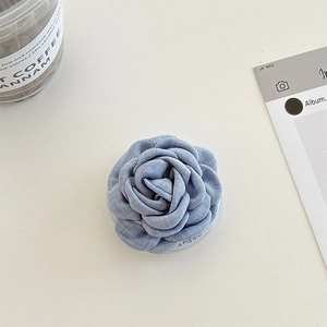 Vue détaillée du support de téléphone camélia en tissu bleu avec texture en jean
