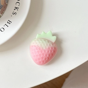 Macro detail of 3D pink strawberry phone grip with realistic seeds and green leaves