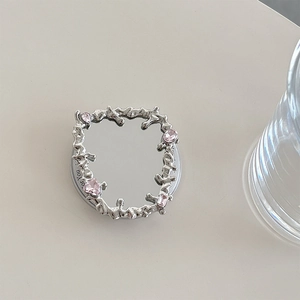 Macro shot of liquid metal style phone socket featuring a mirror and pink gems