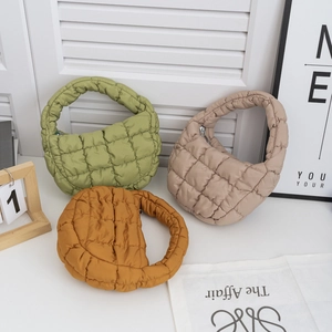 Sacs matelassés en vert, beige et jaune sur fond de décoration intérieure minimaliste