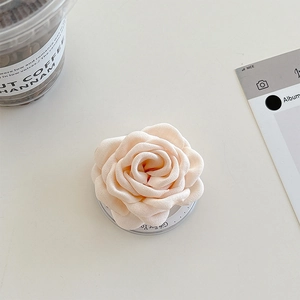 Détail du support téléphone fleur de camélia en tissu 3D avec base en acrylique et pois