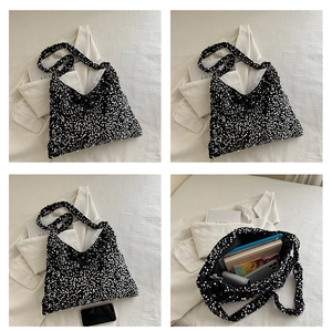 Détail du sac hobo à paillettes noires montrant une grande capacité pour les livres