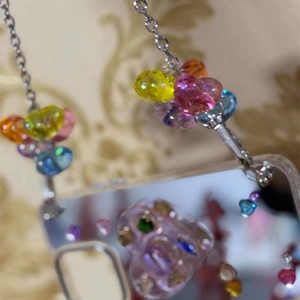Macro detail of colorful resin heart beads on a mirror-finish phone case chain