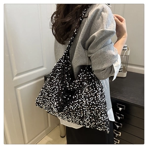 Gros plan des paillettes argentées scintillantes et de la texture d'un sac cabas noir