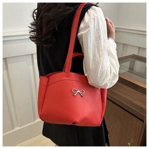 Detailansicht einer roten Shopper-Tasche mit silberner Schleife an der Schulter