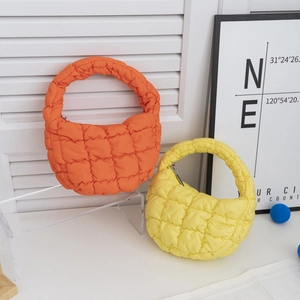 Détail de mini sacs matelassés orange et jaune avec fermeture éclair et texture douce