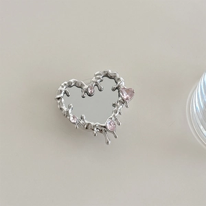 Close-up of liquid metal heart phone grip with pink zircon inlay and Y2K aesthetic