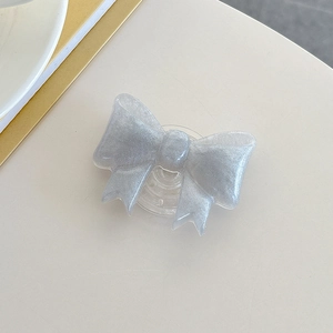 Detail of silver glitter bow-shaped phone griptok with transparent expandable stand