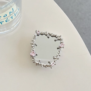Close-up of lava style silver phone grip with pink crystals and makeup mirror