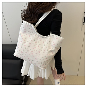 Detail of white canvas tote bag featuring pink butterfly and tulip floral patterns