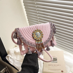 Borsa a mano bohémien in paglia rosa con frange viola e nappe per la spiaggia estiva