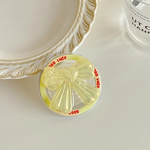 Detailed macro view of laser ribbon bow phone socket with heart charm and Good Luck text