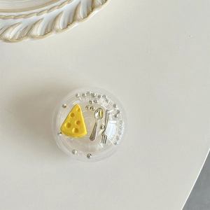 Macro shot of phone grip featuring miniature cheese, silver cutlery and metallic beads