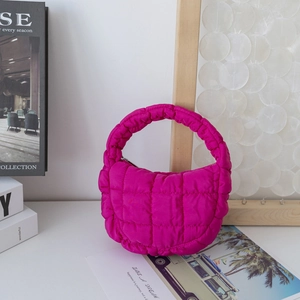 Détail du sac matelassé rose fuchsia avec texture bulle et fermeture éclair supérieure
