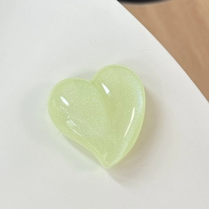 Macro shot of light green glitter heart phone grip with glossy resin finish