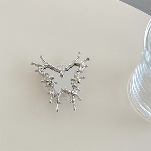 Detail of silver butterfly phone grip with pink zircon stones and liquid metal finish