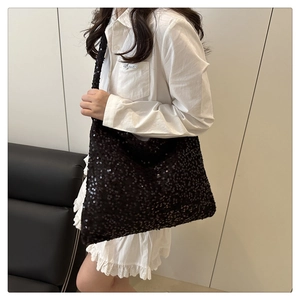 Gros plan sur la texture scintillante des paillettes noires du grand sac hobo