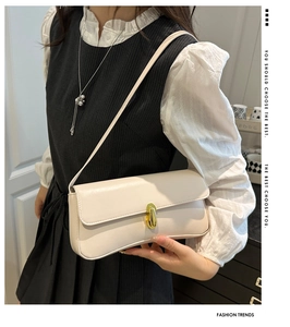 Detail of minimalist beige faux leather shoulder bag with elegant golden oval twist lock