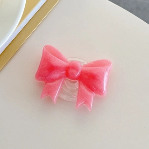 Detailed view of pink glitter bow phone grip with clear retractable socket base