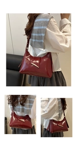 Detail showing the burgundy glossy faux leather texture and metallic buckle of the bag