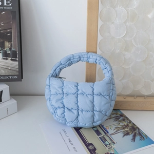 Détail du sac à main nuage matelassé bleu ciel avec une texture à carreaux doux