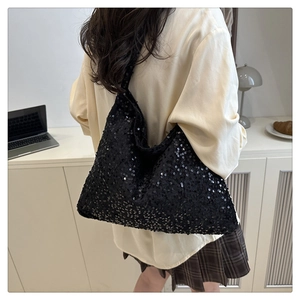 Détail d'un grand sac hobo à paillettes noires montrant la texture brillante et l'espace