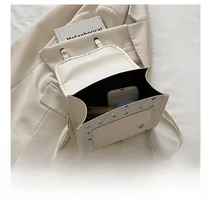 Capacity display of a minimalist cream flap crossbody bag showing inner storage space