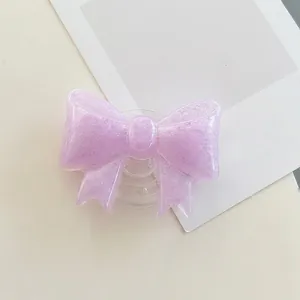 Detail of purple bow phone grip made of translucent resin with shimmering purple glitter