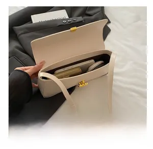 Interior view showing capacity of off-white leather shoulder bag with gold twist lock
