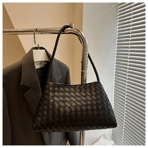 Close-up of black woven shoulder bag with Intrecciato pattern on a metal hanger