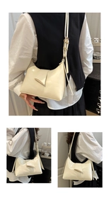 Detail view of cream leather hobo bag with a polished finish and adjustable shoulder strap