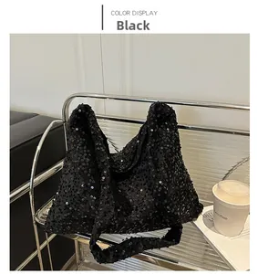 Détail de grandes paillettes noires sur un sac cabas avec une texture brillante