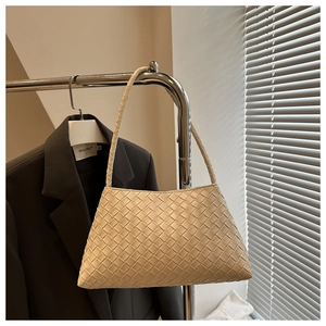 Detail of cream woven leather shoulder bag showing intricate braided craftsmanship and texture