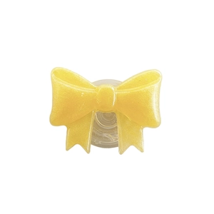 Sparkly yellow bow phone socket grip with collapsible stand on white background