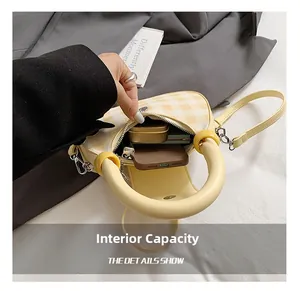 Detail view of the yellow checkered crossbody bag interior showing phone storage