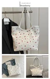 Detail shot of the white floral tote bag featuring a cute pink strawberry print pattern