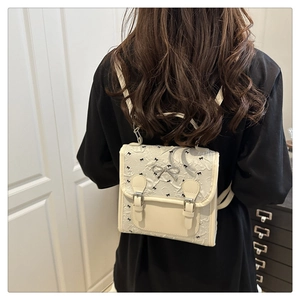 Detail of off-white mini backpack with jacquard texture and silver bow charm