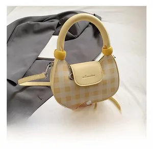 Detail of yellow checkered hobo bag with thick round handle and detachable shoulder strap